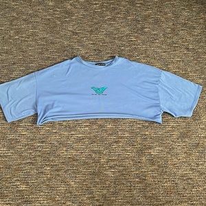 baby blue, raw-edge cut crop top. “become the change”